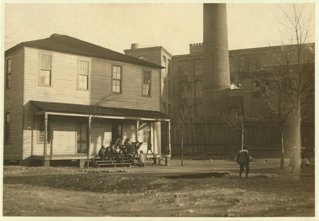 "The Mill School" at Avondale. The mill gate is but a few feet to the right of the photo and the employees pass through the school yard continually. From all I could gather on the question, the school is only a makeshift, because the mill children go here only the eight weeks of the year to comply with the law. Attendance is irregular. In the lowest first grade, with a child of six years, were two girls of fourteen and fifteen who had been to school but two weeks in their lives.