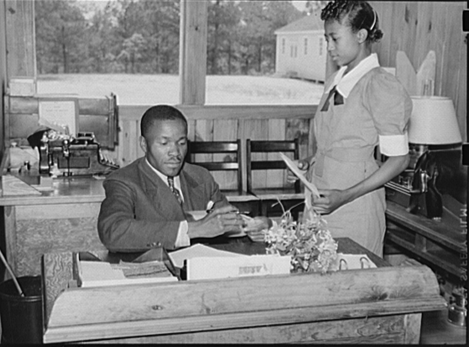 School - students learning office and secretarial skills helping principal