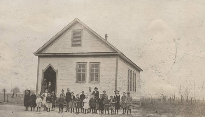 Children_and_adults_in_front_of_a_school_building_in_rural_Baldwin_County_Alabama