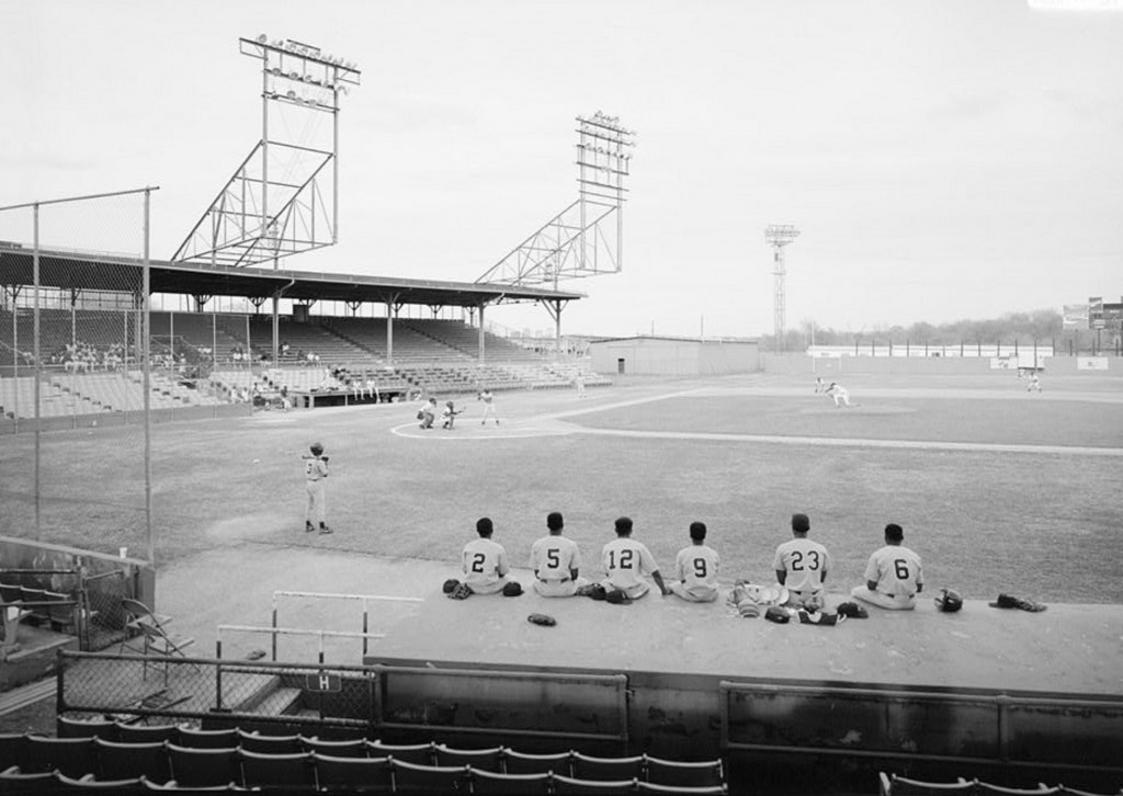 VIEW OF PLAYING FIELD WITH HOME PLATE TO CENTER, STANDS IN THE BACKGROUND AND DUGOUT IN THE FOREGROUND, LOOKING WEST