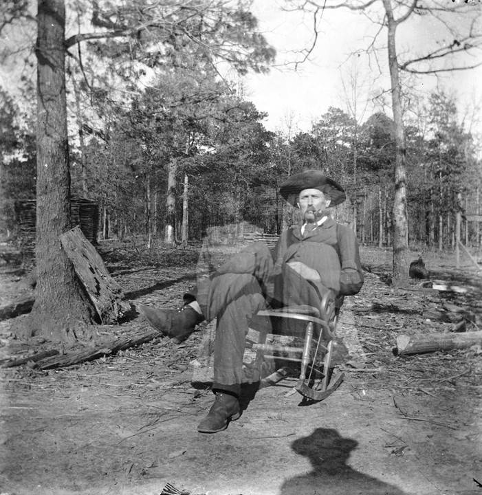Man_seated_in_a_rocking_chair_in_a_dirt_yard_in_Montevallo_Alabama
