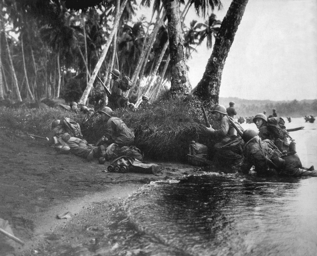 Landing operations on Redova Island, Solomon Islands, 30 June 1943. Attacking at the break of day in a heavy rainstorm, the first Americans ashore huddle behind tree trunks and any other cover they can find. (Navy) NARA FILE #: 080-G-52573 WAR & CONFLICT BOOK #: 1176