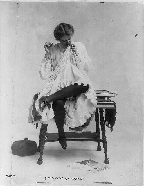 A Stich in Time -Woman seated on small table with legs crossed, mending dress, which she is wearing ca. 1890 (Library of Congress)