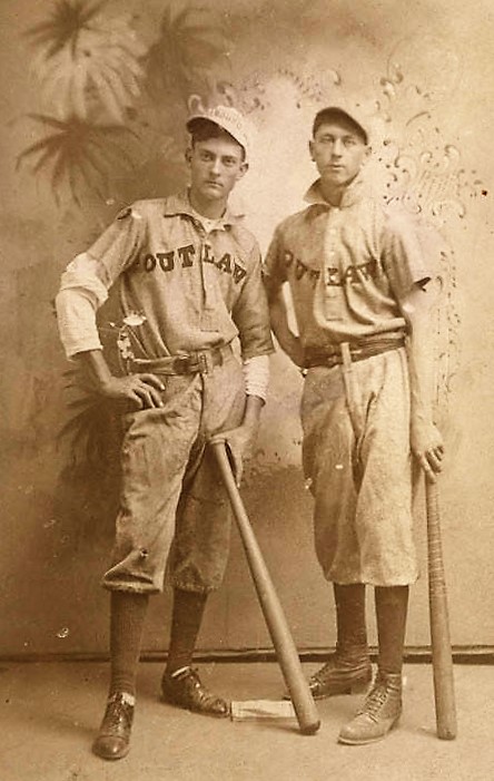 Two young men in baseball uniforms. Their shirts say Outlaw ca. 1900 – Duke and Weeks family collection Q9479 ,